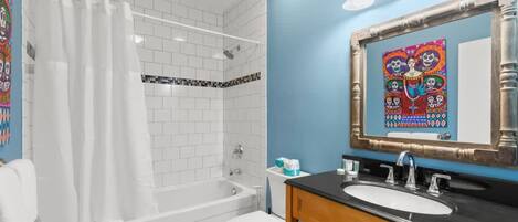 A bathroom with a bathtub, toilet, and sink.
