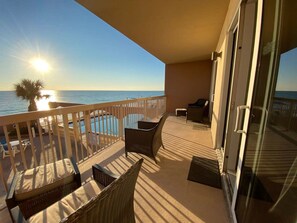 A balcony with a view of the ocean, a pool, and outdoor furniture. - Coastal Condo 607 by Brightwild Beachfront (Panama City Beach)