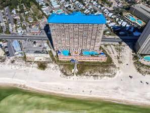 A high-rise hotel with a blue roof, multiple balconies, and a pool area. - Coastal Condo 607 by Brightwild Beachfront (Panama City Beach)