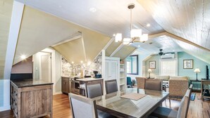 A spacious loft-style apartment with a high ceiling, exposed beams, and a kitchen area with a stone backsplash. - Sky Loft by Brightwild Penthouse in Prime Spot (Key West)