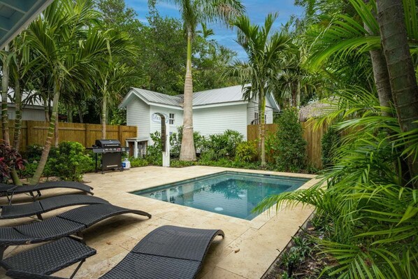 Relax by the pool surrounded by lush greenery and enjoy outdoor cooking facilities.