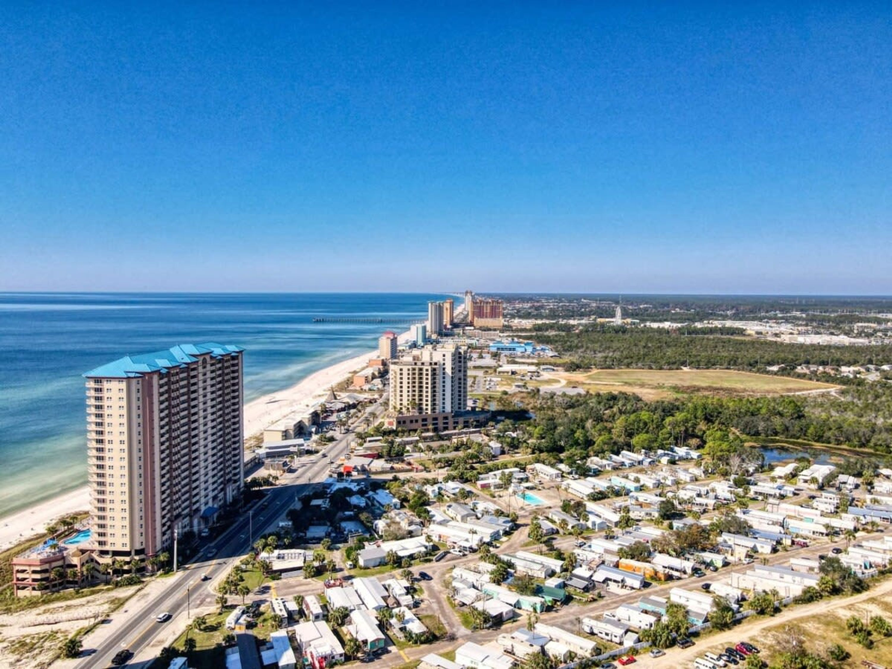A coastal area with high-rise hotels, a beach, and a residential zone with mobile homes.