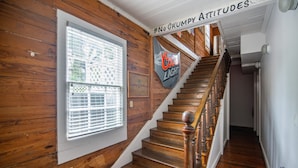 A wooden staircase with a sign reading "No Grumpy Attitudes" and a Coors Light banner. - Commodore s Compound by Brightwild Huge Home (Key West)