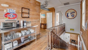 A restaurant interior with wooden walls, a buffet counter, and a staircase. - Commodore s Compound by Brightwild Huge Home (Key West)