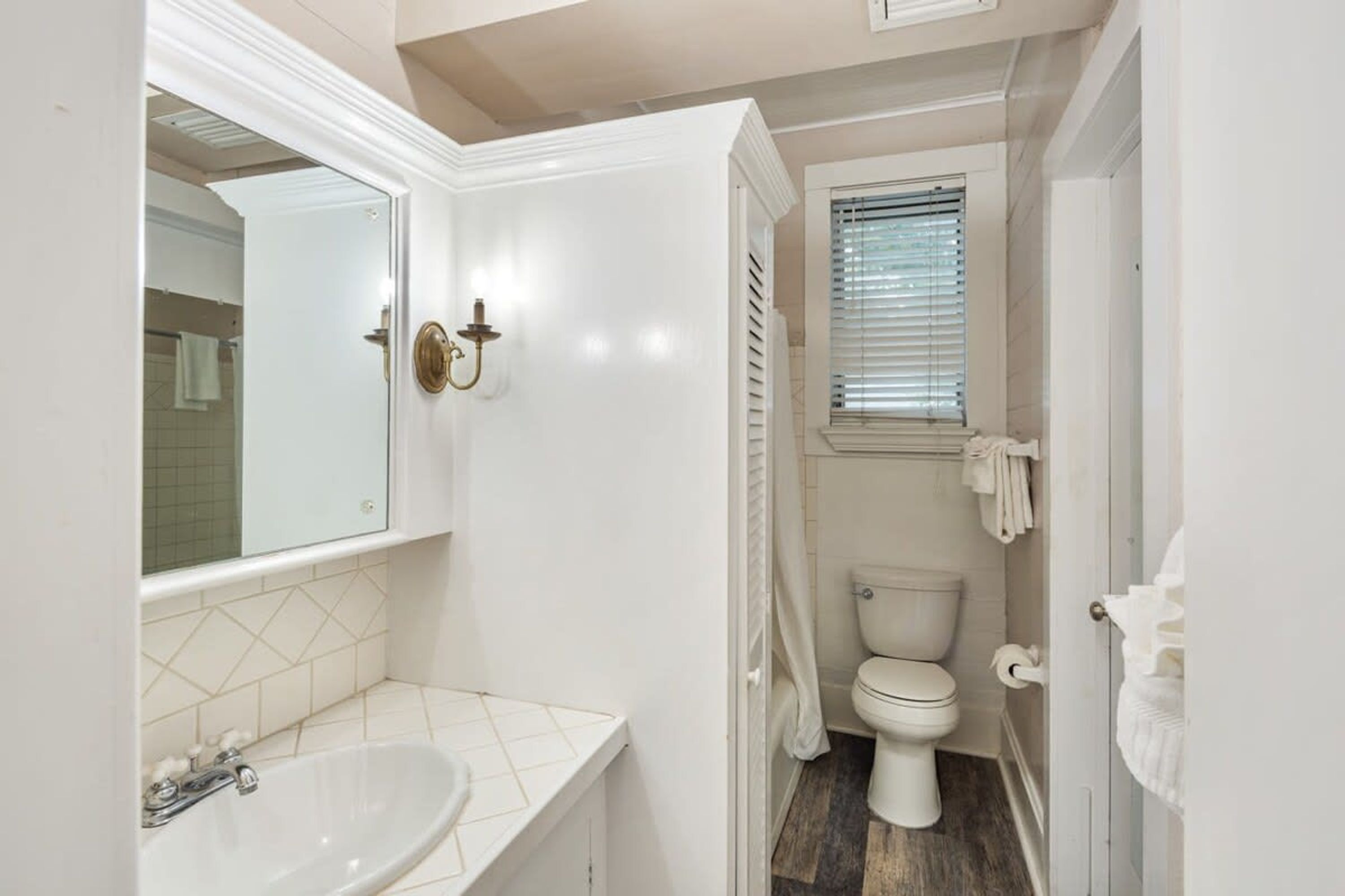 Une petite salle de bain avec un lavabo blanc, des toilettes et un espace douche.