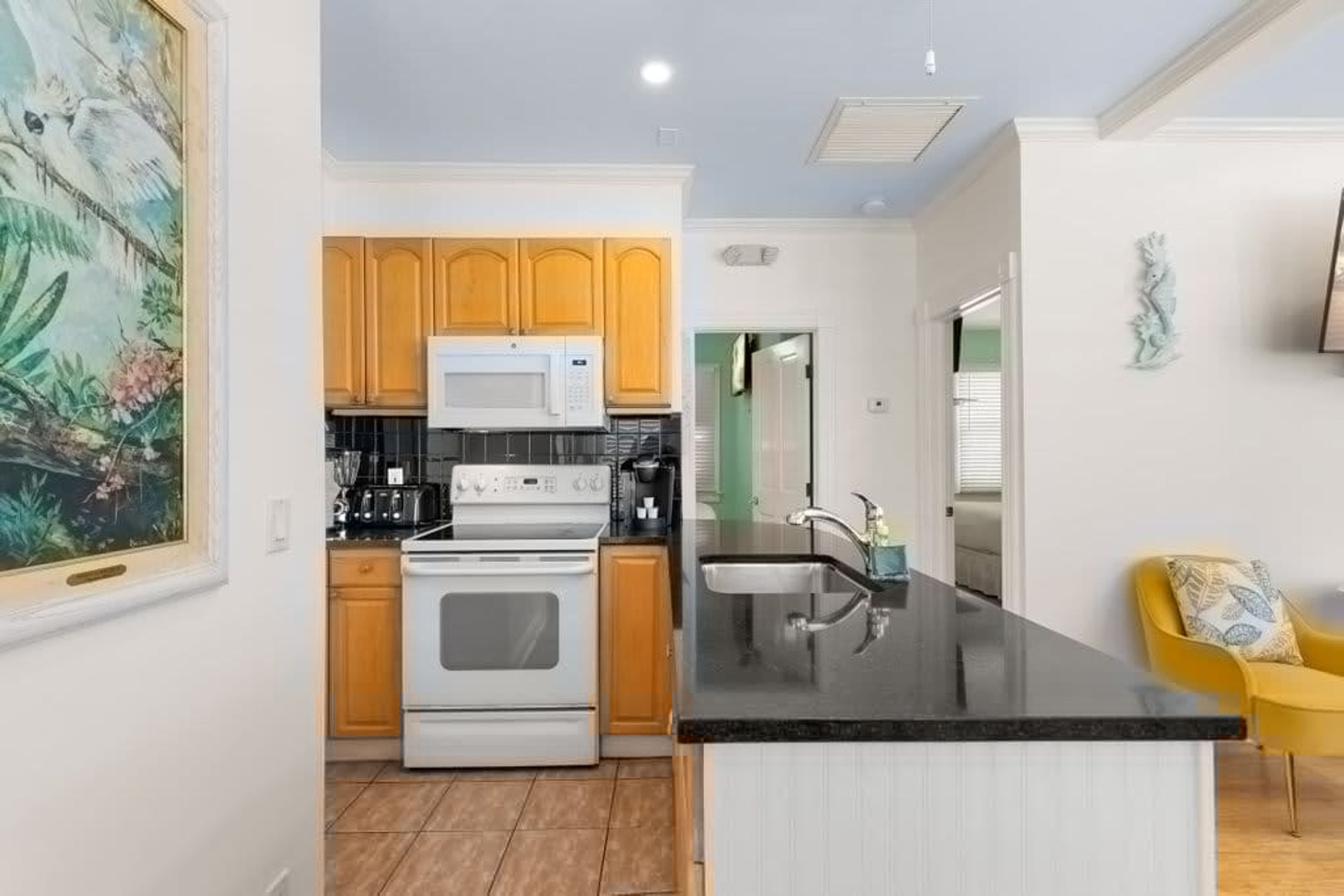 A kitchen with wooden cabinets, a microwave, an oven, and a black countertop.
