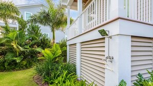 A residential building with a covered porch, surrounded by lush greenery and a well-maintained lawn. - Capmar House by Brightwild Huge Home Pool (Key West)