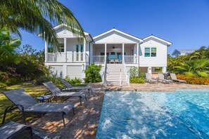 A white two-story house with a balcony and a swimming pool. - Capmar House by Brightwild Huge Home Pool (Key West)