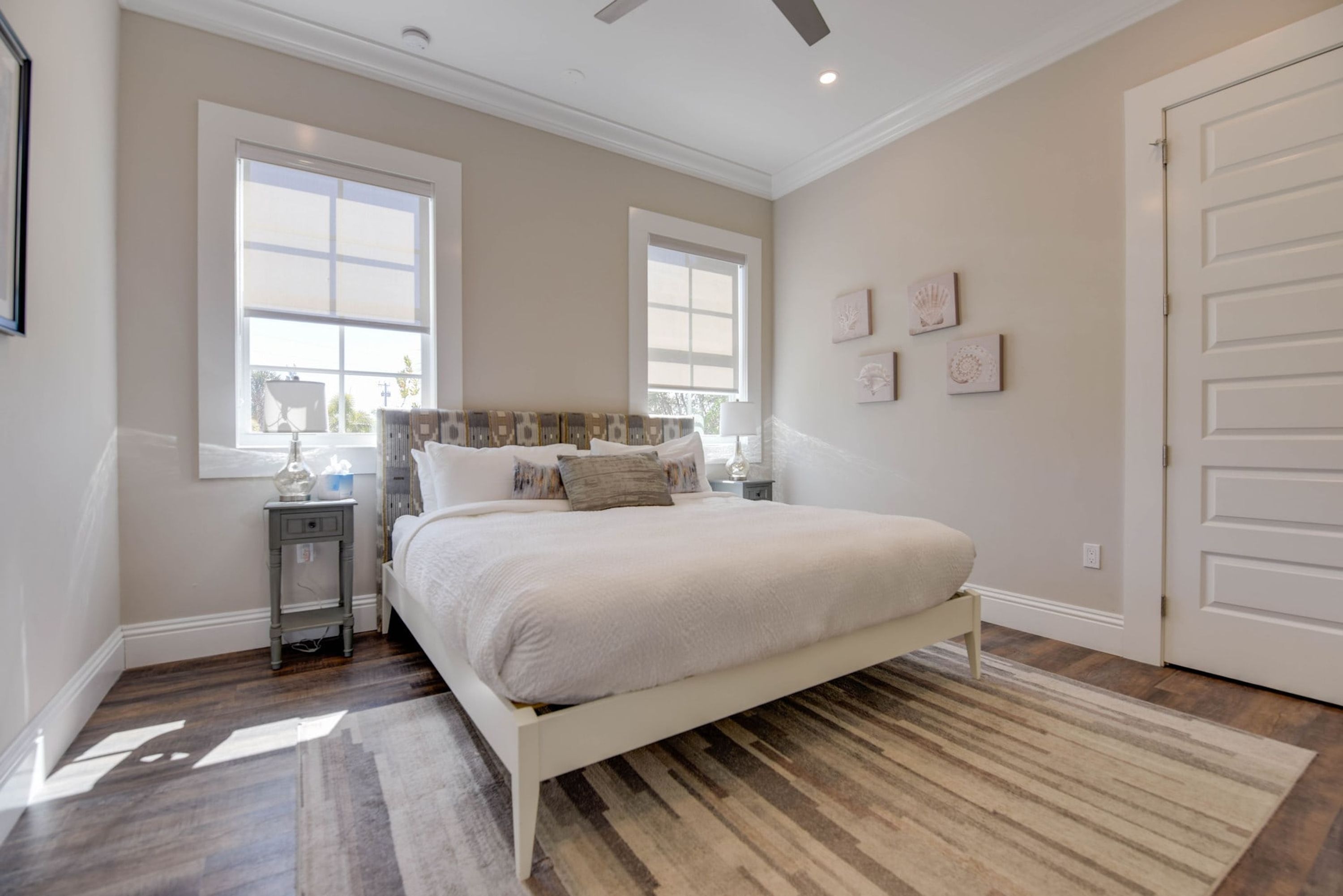 A bedroom with a large bed, two bedside tables, a nightstand, and a window.