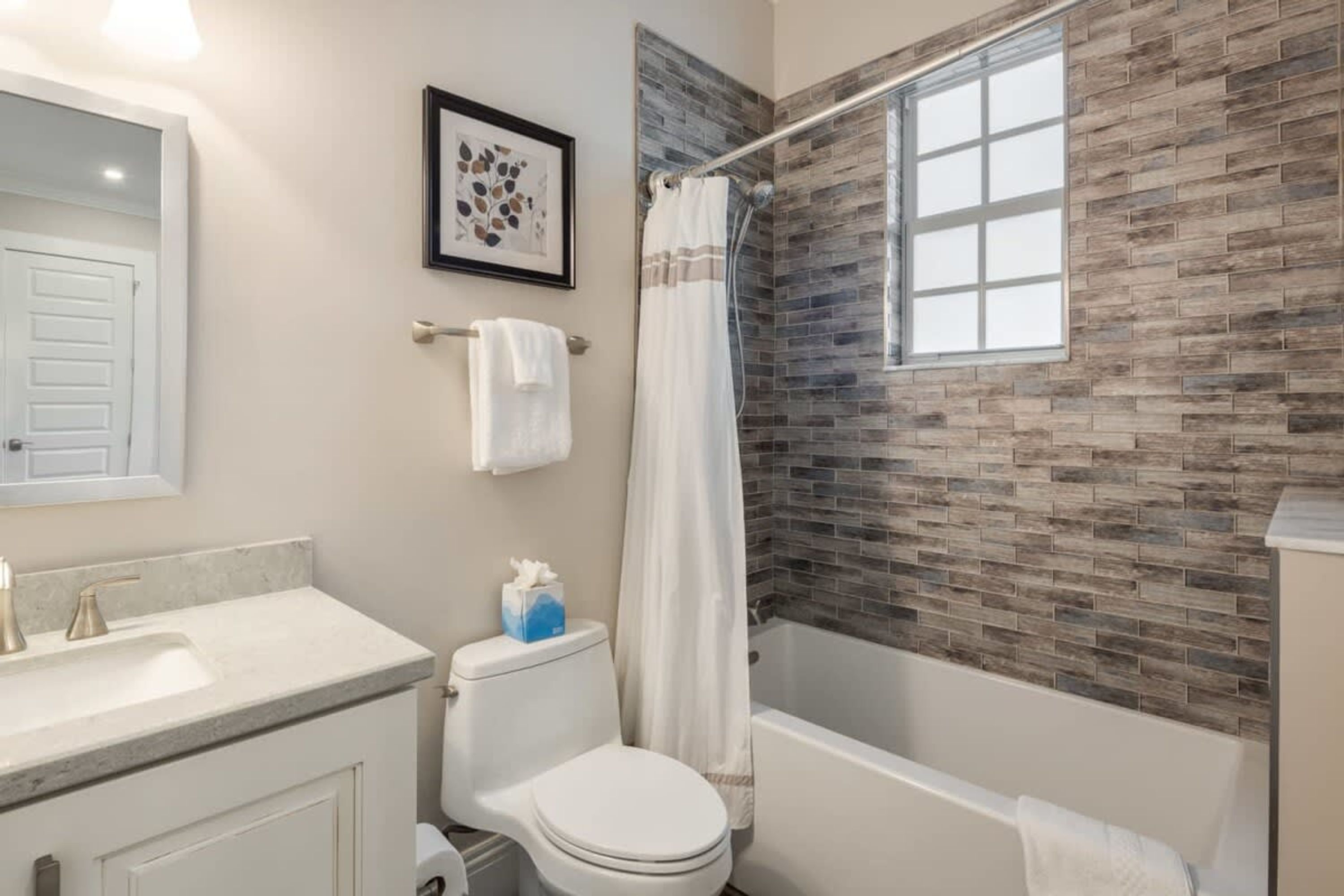 A bathroom with a shower, toilet, and sink.