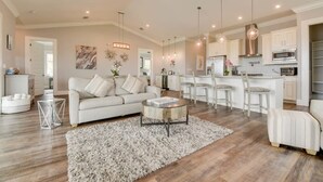 Un salon moderne avec un canapé, une table basse et un tapis. Il y a également un coin cuisine avec un bar et des sièges.