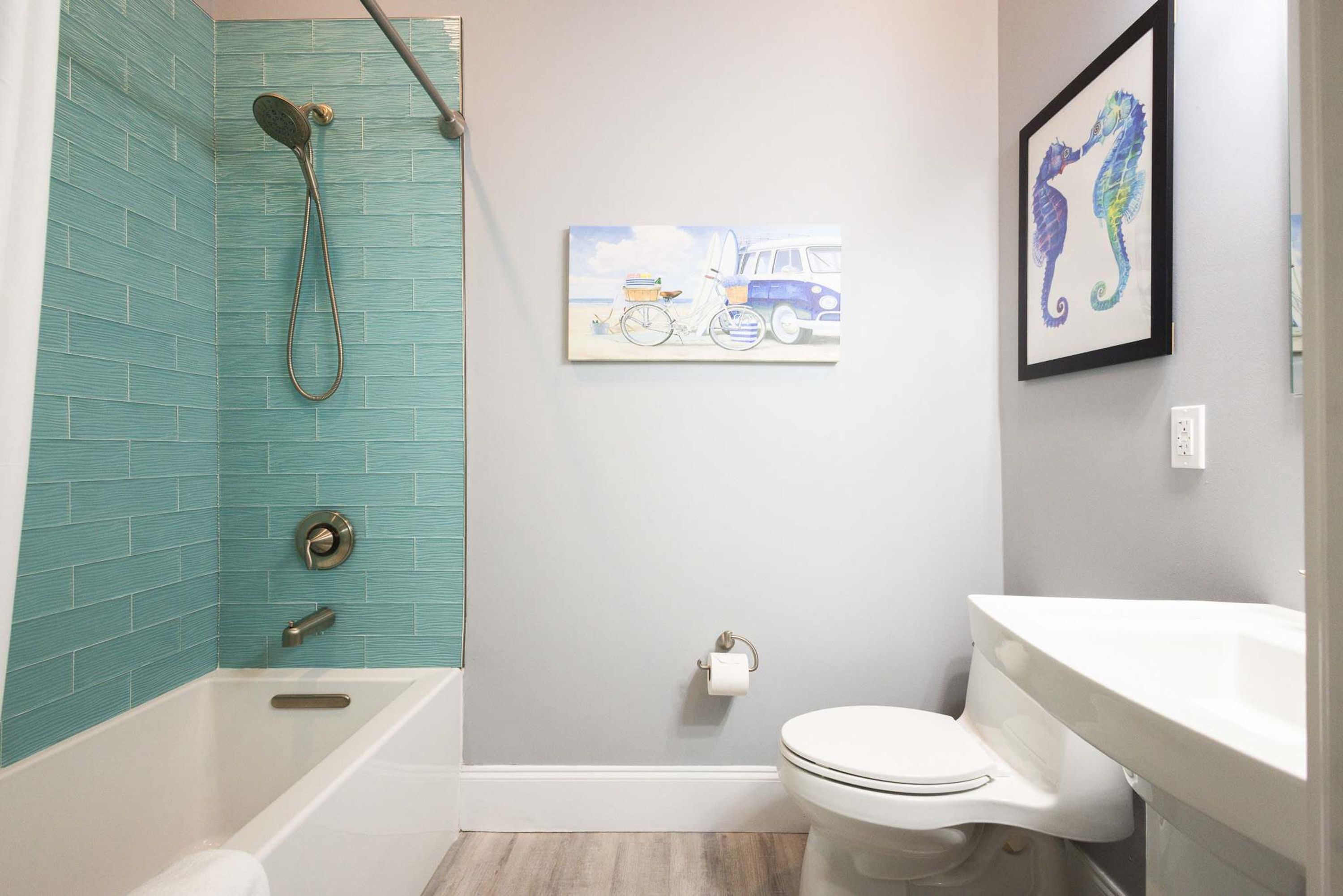 A bathroom with a bathtub, toilet, and sink.