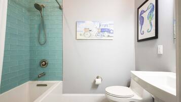 A bathroom with a bathtub, toilet, and sink.