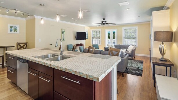 A modern kitchen with a large island, built-in appliances, and pendant lighting. - Cloud Suite on Duval Luxury Condo Epic Location (Key West)