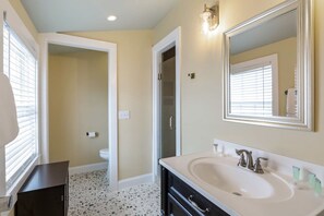 A bathroom with a white sink, a mirror, and a toilet. - Cloud Suite on Duval Luxury Condo Epic Location (Key West)