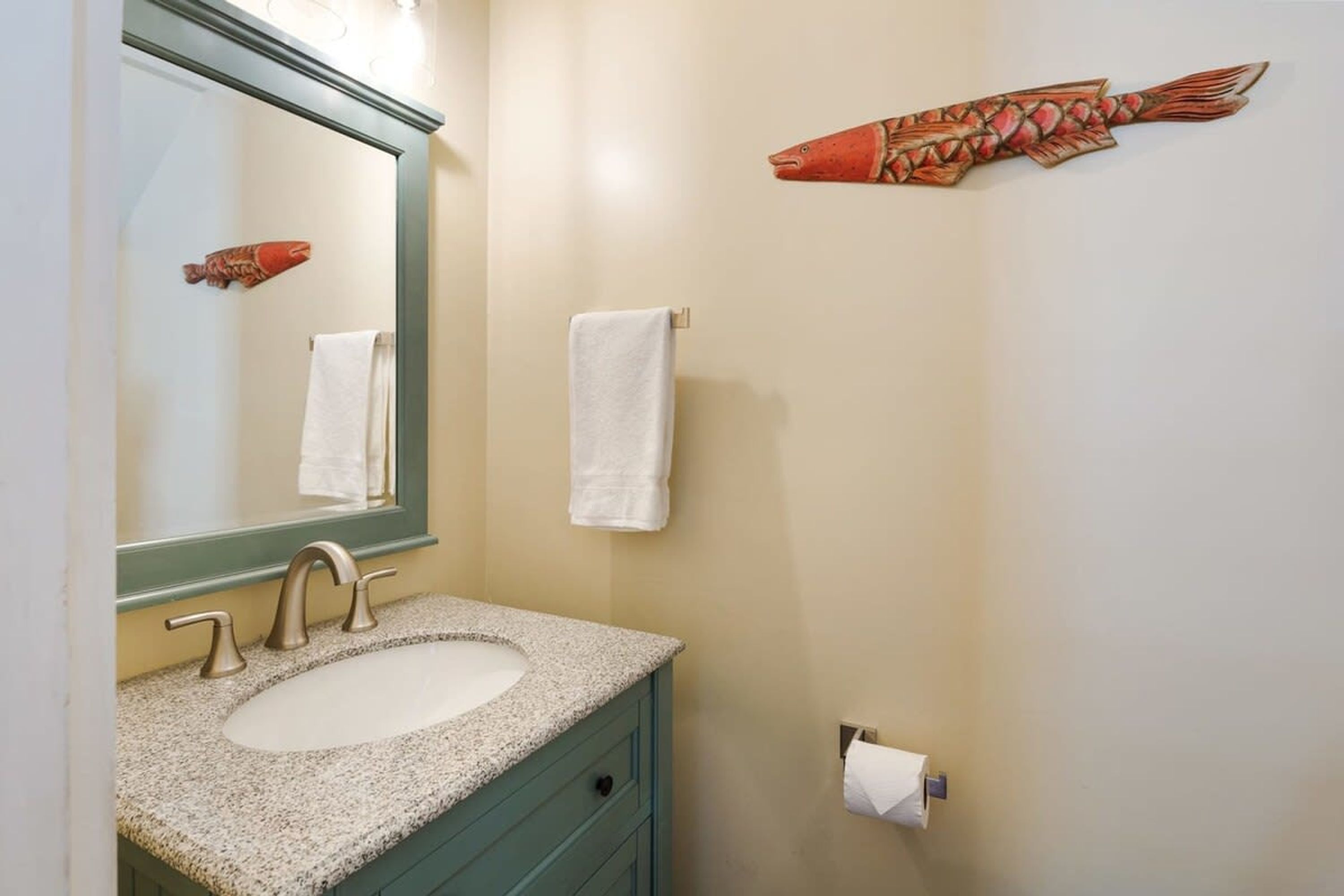 Ein Badezimmer mit Waschbecken, Spiegel und zwei Handtüchern, die an der Wand hängen.