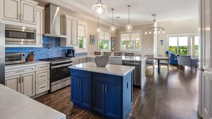 A modern kitchen with a central island, stainless steel appliances, and pendant lighting. - Suncoast House by Brightwild Pool Boat Dock (Key West)