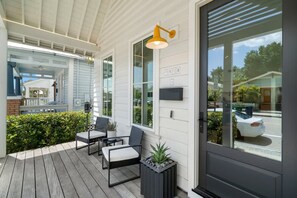 En inglasad veranda med två stolar, ett bord och en krukväxt.