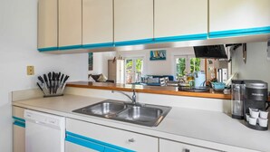 A compact kitchen with a dishwasher, double sink, and a coffee maker. - Sunnyside Up by Brightwild Pool Parking (Key West)