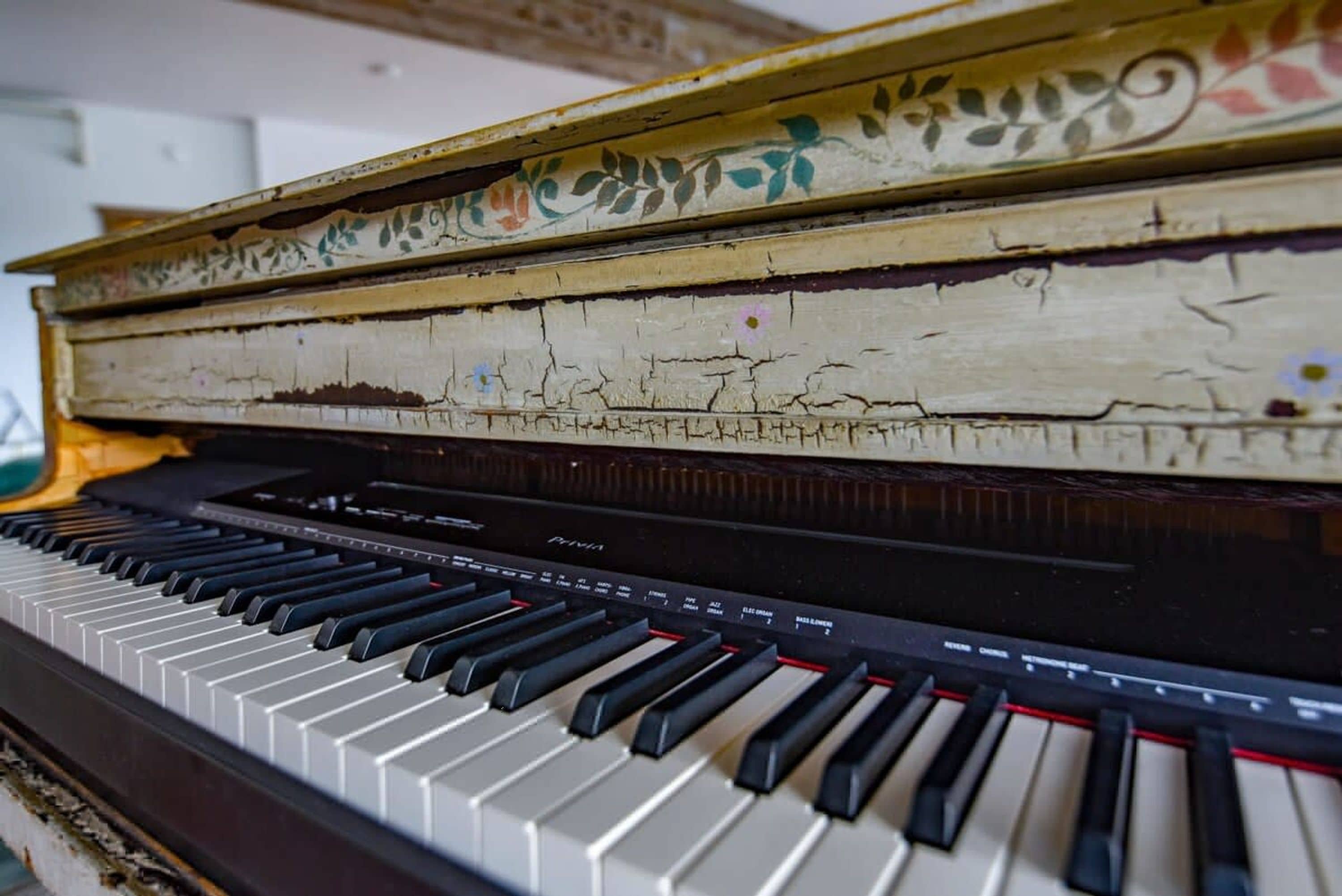 Un piano con una tapa decorativa y desgastada.