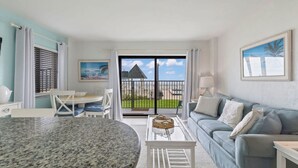 Una sala moderna con comedor, sofá y vistas al exterior.