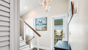 A staircase with white railings and a wooden handrail, leading to a door with a glass panel. - Southernmost View by Brightwild Pool H20 Views (Key West)