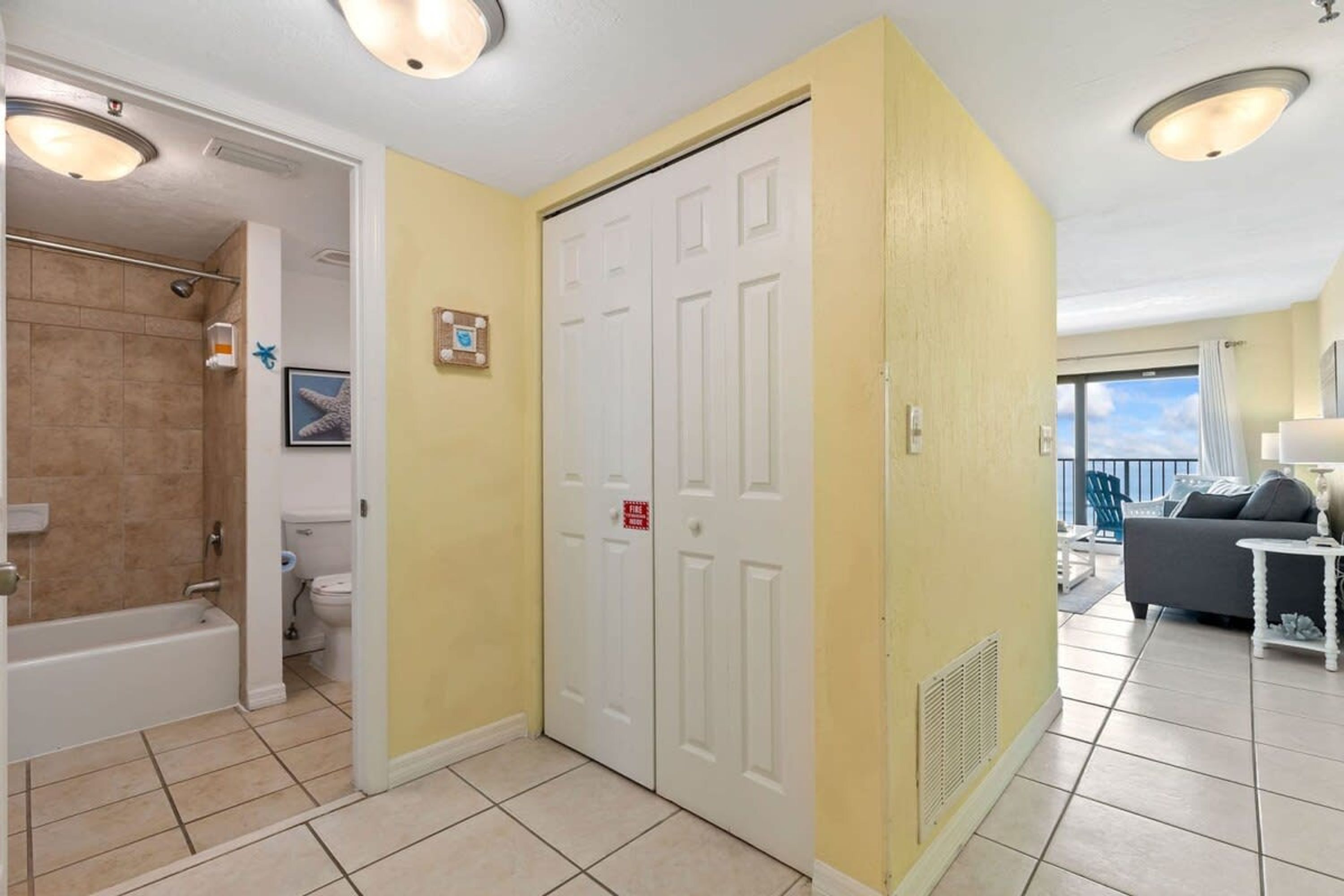 A hotel room with a bathroom, a balcony, and a living area.