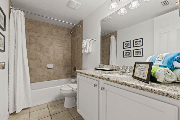 A bathroom with a bathtub, toilet, and sink. - Ocean Views Pool Hot Tub Seahorse Suite 907 (Daytona Beach Shores)