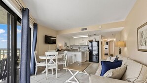 A modern apartment with a dining area, kitchen, and balcony. - Ocean Views Pool Hot Tub Seahorse Suite 907 (Daytona Beach Shores)