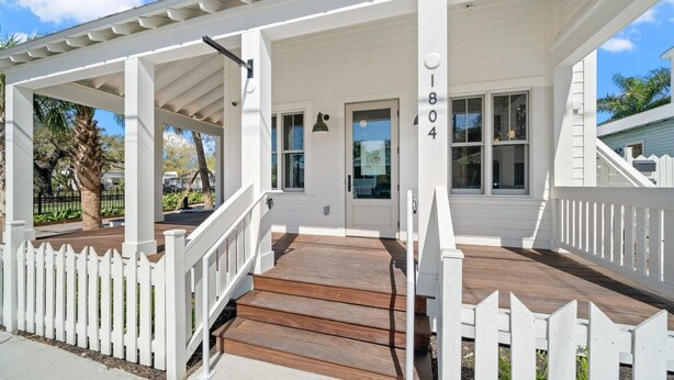 A white building with a wooden porch and white picket fence. - Romeo Julieta 2 Epic Studios Steps to 7th Ave (Tampa)