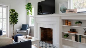 Ein Wohnzimmer mit Kamin, Fernseher und Bücherregal.