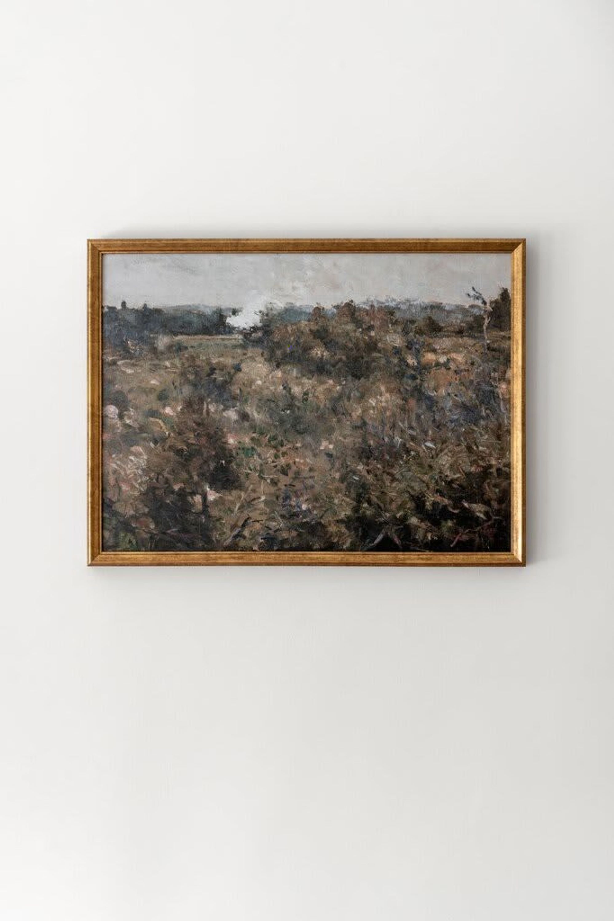 Un cuadro enmarco con paisaje y marco de madera.