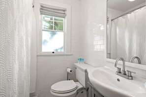 Une salle de bain avec des toilettes, un lavabo et une fenêtre.