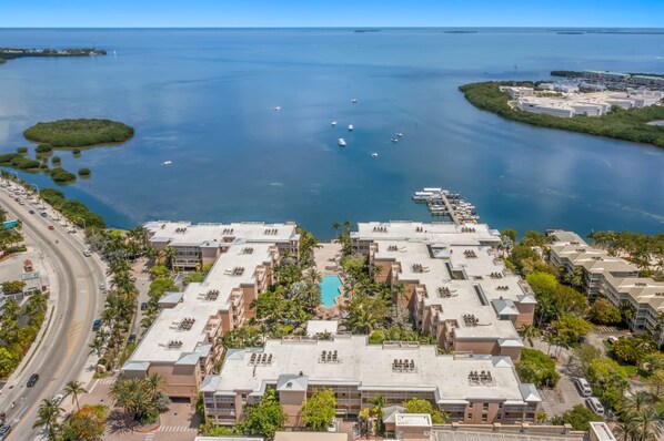 A coastal hotel with multiple buildings, a swimming pool, and a marina with boats. - Resort View 1BR Suite (Key West)