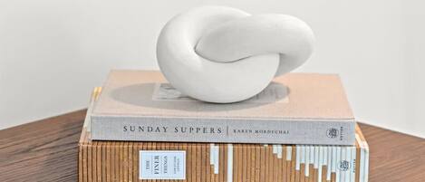 A stack of books with a white sculpture on top.