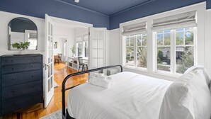 Un dormitorio con cama, cómoda y ventana con vistas al exterior.