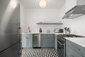 A modern kitchen with a checkered floor, stainless steel appliances, and light blue cabinets. - NEW The Adaline 4 Updated Hyde Park Apt (Tampa)