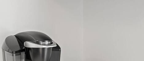 Una cafetera Keurig con un portal cápsulas de café y una bandeja de cápsulas.