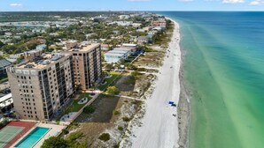 A coastal cityscape with a beachfront hotel featuring multiple floors, a swimming pool, and a view of the ocean. - Reflections 504 Oceanfront Pool Beach View (Indian Rocks Beach)