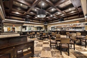 Enjoy meals in a dining area with multiple tables and chairs, exposed beams, and pendant lights.