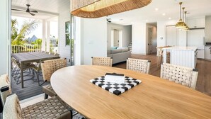 Una cocina moderna con armarios blancos, encimera de madera y una lámpara colgante.