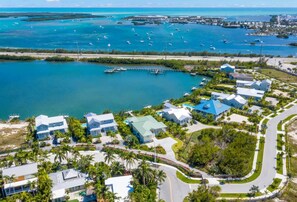 An aerial view of a coastal residential area with houses, a marina, and clear blue waters. - New Windrose House by Brightwild Pool (Key West)