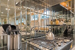 A modern kitchen with stainless steel appliances, a kettle, and utensils on a countertop. - Soho Serenity by Brightwild Pool Hot Tub (Tampa)
