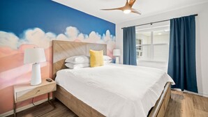 A bedroom with a bed, nightstand, lamp, and a ceiling fan. - Deluxe King Condo Updated Suite by the Beach! (Clearwater Beach)