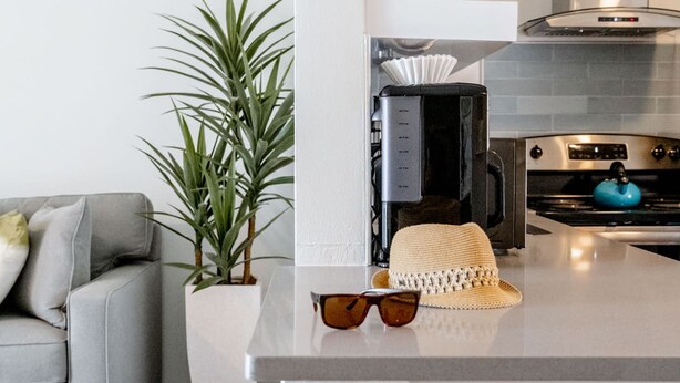 A modern kitchen with a built-in island, a coffee machine, and a stove. - Deluxe King Condo Updated Suite by the Beach! (Clearwater Beach)