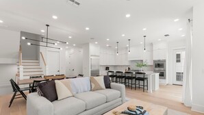 A modern kitchen with white cabinets, a central island, and pendant lighting.