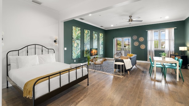 A bedroom with a bed, a dining area with a table and chairs, and a ceiling fan. - NEW Rumba Roost Upscale Ybor Studio On 7th Ave (Tampa)