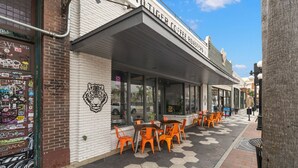 A coffee shop named Blind Tiger Coffee Roasters with outdoor seating and a tiger mural on the wall. - NEW Rumba Roost Upscale Ybor Studio On 7th Ave (Tampa)