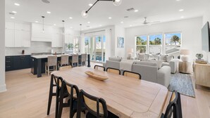 Une cuisine spacieuse avec un coin repas, de grandes fenêtres et un design de plafond moderne.