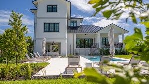A modern two-story house with a swimming pool, outdoor seating, and a well-maintained garden. - Brand New Catchlight House With Private Pool (Key West)
